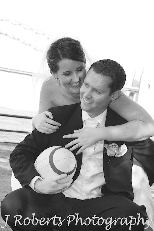 Bridal couple piggy back with rugby ball - wedding photography sydney